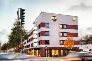 un edificio en una calle de la ciudad con un semáforo en B&B Hotel Kaiserslautern, en Kaiserslautern