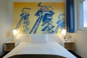 1 dormitorio con 1 cama y una pintura en la pared en B&B Hotel Hamm, en Hamm