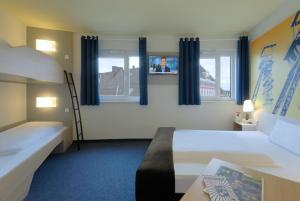 ein Hotelzimmer mit 2 Betten, einer Leiter und Fenstern in der Unterkunft B&B Hotel Hamm in Hamm