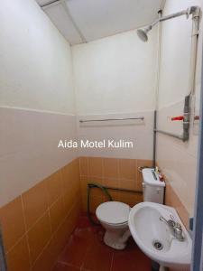 a bathroom with a toilet and a sink at Art Motel Kulim in Kulim