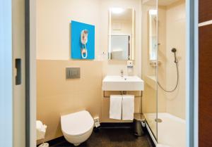 a bathroom with a toilet and a sink and a shower at B&B Hotel Katowice Centrum in Katowice