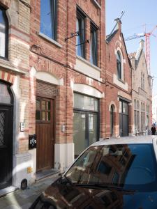 a car parked in front of a brick building at Julie's Boutique Guesthouse Ghent in Ghent