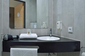 łazienka z umywalką i lustrem w obiekcie B&B Hotel Graz City-Süd w Grazu