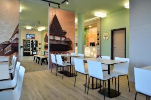 um restaurante com cadeiras brancas e mesas num quarto em B&B Hotel Graz City-Süd em Graz