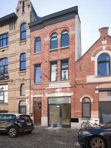 a brick building with cars parked in front of it at Julie's Boutique Guesthouse Ghent in Ghent