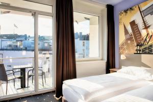 ein Hotelzimmer mit 2 Betten und einem Balkon in der Unterkunft B&B Hotel Kiel-Holstenbrücke in Kiel