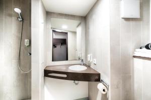 La salle de bains est pourvue d'un lavabo et d'un miroir. dans l'établissement B&B Hotel Kiel-Holstenbrücke, à Kiel