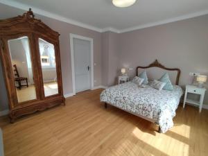 1 dormitorio con cama y espejo grande en gîte le carthame, en Elsenheim
