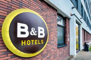 een b b hotelbord aan de zijkant van een bakstenen gebouw bij B&B Hotel Kassel-City in Kassel