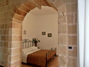 a bedroom with a bed in a stone archway at Il Corallo del Salento in Vignacastrisi