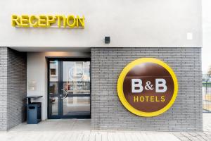 um sinal de hotel b b no lado de um edifício em B&B Hotel Gießen em Giessen