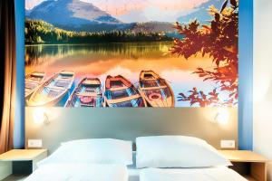 B&B Hotel Kempten في كمبتن: غرفة نوم فيها لوحة قوارب في الماء