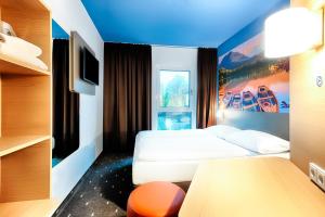 um quarto de hotel com uma cama e uma televisão em B&B Hotel Kempten em Kempten