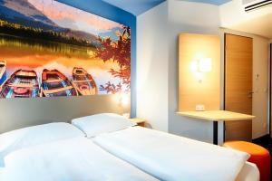 a bedroom with a large painting of boats on the wall at B&B Hotel Kempten in Kempten