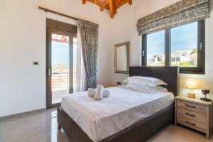 a bedroom with a large bed with a large window at Villa Nikolaos 2 in Fánai