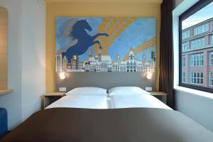 a bedroom with a bed with a painting on the wall at B&B Hotel Hannover-City in Hannover