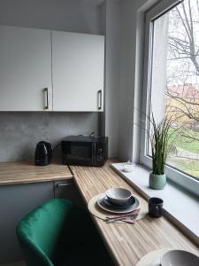 a kitchen with a table with a microwave and a window at Tabago Studio 7 in Kędzierzyn-Koźle