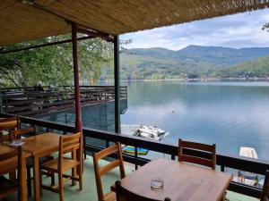 a view of a lake with tables and chairs at Green House with Lake View in Perućac