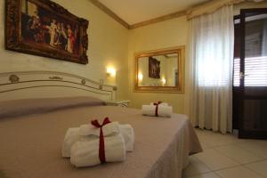 una camera da letto con un letto con asciugamani e uno specchio di DIO DEL MARE LUXURY ROOM a Porto Cesareo
