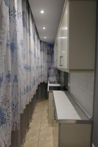 una piccola cucina con armadietti bianchi e tenda di Sonche Hostel a Tirana