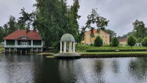 a house with a fountain in the middle of a lake at Palmse Distillery Guesthouse in Palmse