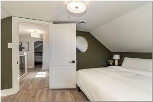 ein Schlafzimmer mit einem weißen Bett und einer weißen Tür in der Unterkunft Enjoy beautiful, fresh home in trendy Ohio City in Cleveland