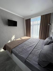 um quarto com uma cama grande e uma janela em Downtown Accommodation em Chişinău