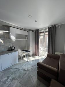 een keuken en een woonkamer met een bank en een tafel bij Downtown Accommodation in Chişinău