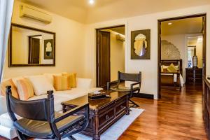 uma sala de estar com um sofá e uma mesa em Pawanthorn Samui - SHA Plus em Chaweng