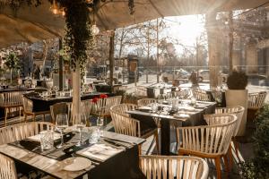 a restaurant with tables and chairs with a view at Hospes Puerta de Alcalá, a Member of Design Hotels in Madrid