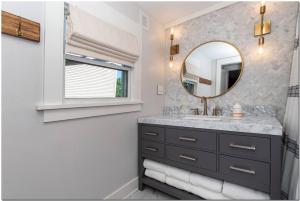 ein Bad mit einem Waschbecken und einem Spiegel in der Unterkunft Enjoy beautiful, fresh home in trendy Ohio City in Cleveland