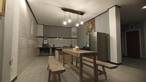 a kitchen with a wooden table and a refrigerator at Gending Sari House in Ubud