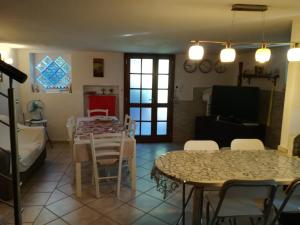 a dining room and living room with a table and chairs at Il Ritiro Estivo in Rosignano Solvay