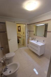 bagno con lavandino, servizi igienici e specchio di DIO DEL MARE LUXURY ROOM a Porto Cesareo