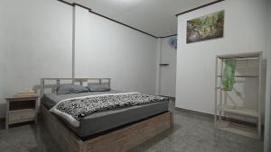 1 dormitorio con 1 cama en una habitación blanca en Gending Sari House, en Ubud
