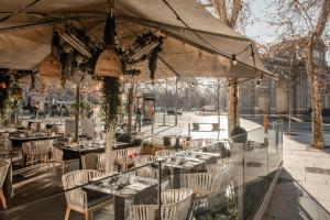 a restaurant with tables and chairs and a large tent at Hospes Puerta de Alcalá, a Member of Design Hotels in Madrid