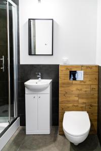 a bathroom with a white toilet and a sink at Apartamenty Silver Place in Szczecin