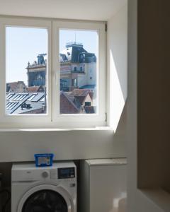 a washing machine in a room with a window at Julie's Boutique Guesthouse Ghent in Ghent