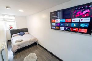 Habitación con cama y TV en la pared. en Stylish Studio for short term near the City!, en Birmingham