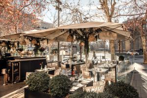 a restaurant with tables and a large umbrella at Hospes Puerta de Alcalá, a Member of Design Hotels in Madrid