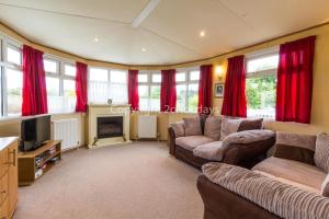 a living room with two couches and a tv at Great Dog Friendly Caravan To Hire With Field Views In Norfolk Ref 10132b in Belton