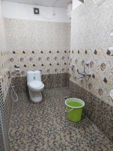 a bathroom with a toilet and a bucket in it at Andaman Runway in Port Blair