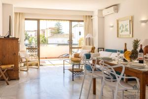 - un salon avec une table et des chaises dans l'établissement Living4Malaga Fuengirola Beach&Pool Apartment, à Fuengirola
