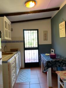 cocina con fregadero y puerta con mesa en Molino El Mastral, en Tarifa