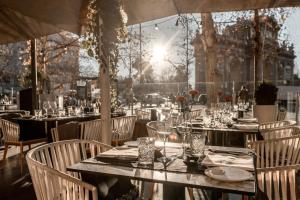 a table with plates and glasses on it in a restaurant at Hospes Puerta de Alcalá, a Member of Design Hotels in Madrid