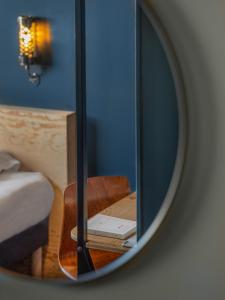 lustro odzwierciedlające pokój z łóżkiem i krzesłem w obiekcie Eklo Montpellier Centre Gare w Montpellier