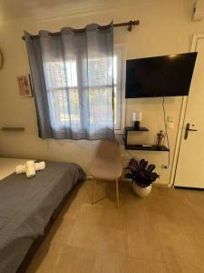 a bedroom with a bed and a window and a chair at Mon Repo Apartment Corfu in Corfu Town +3 photos