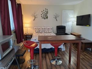 a small room with a bed and a table and stool at Three Island Motel in Bobcaygeon