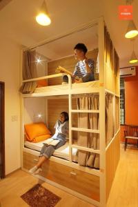 a couple of people sitting in a bunk bed at City Hostel Da Nang in Danang