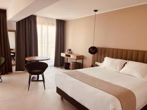 Hôtel Spa Restaurant La Madrague في لوسيانا: غرفة فندقية بسرير كبير وطاولة